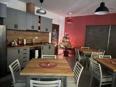 a kitchen with a table and chairs and a christmas tree at Villa YoSi - rooms in Sapareva Banya