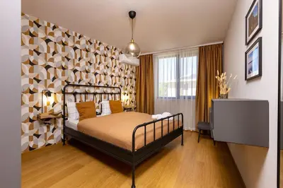 a bedroom with a bed and a wall with wooden floors at Stylish apt 'Photo Booth' with an amazing location in Plovdiv
