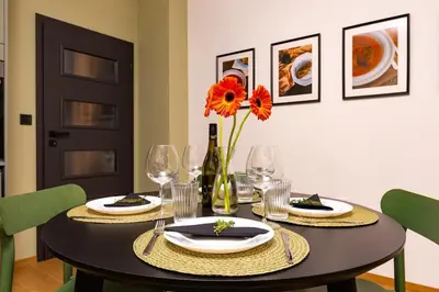 a dining room table with a bottle of wine and flowers at Stylish apt 'Photo Booth' with an amazing location in Plovdiv