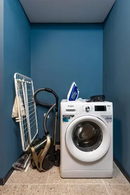 a washing machine in a room with a blue wall at Stylish apt 'Photo Booth' with an amazing location in Plovdiv