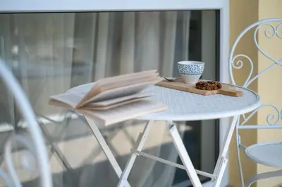a table with a coffee cup and books on it at Студио 9 Парк Панорама in Hisarya