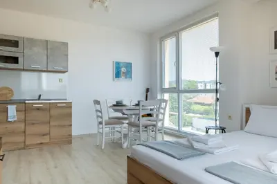 a bedroom with a bed and a table and chairs at Студио 9 Парк Панорама in Hisarya