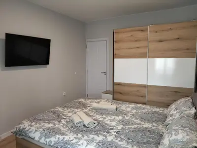 a bedroom with a bed and a flat screen tv at Your Sweet Home in Sofia