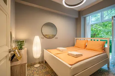 a bedroom with a bed with orange sheets and a mirror at VIP APARTMENT ViTOSHA 69 blvd 3 bdrm - TOP LOCATION in Sofia