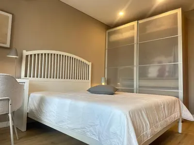 a bedroom with a white bed and a glass wall at Апартамент В 54 в Сграда МОНА in Sofia