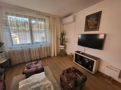 a living room with a flat screen tv and a large window at Йони in Teteven