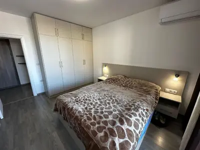 a bedroom with a bed and a desk and cabinets at Apartment Aria 6 in Velingrad