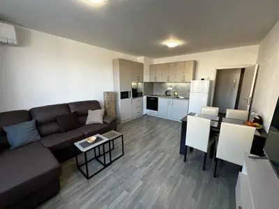 a living room with a couch and a table and a kitchen at Apartment Aria 6 in Velingrad