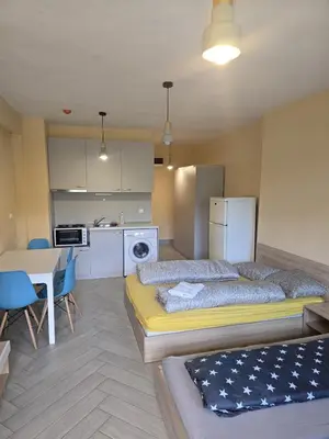 a bedroom with a bed and a table and a kitchen at Green Oasis in Sofia