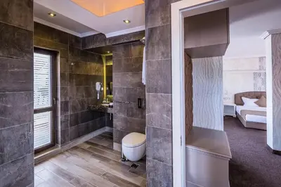 a bathroom with a toilet and a bed in a room at 8 1/2 Art Guest House in Plovdiv