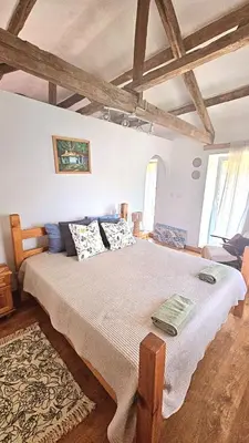 a bedroom with a large bed with pillows on it at Balkan Barn in Tŭzha