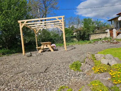 a wooden picnic table and a wooden pergola at Balkan Barn in Tŭzha