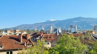 a view of a city with buildings and mountains at Central 1-Bedroom Apartment with Balcony & View in Sofia