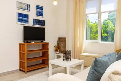 a living room with a tv and a couch at Azuuro - 1BD near the city center by Flat Manager in Plovdiv