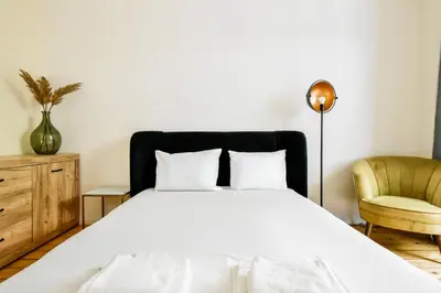 a bedroom with a bed and a chair at Classic Charm - 2BD central Apartment by FlatManager in Sofia