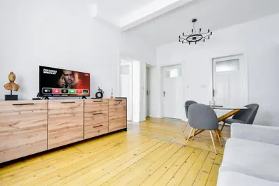 a living room with a tv on a wooden dresser at Classic Charm - 2BD central Apartment by FlatManager in Sofia