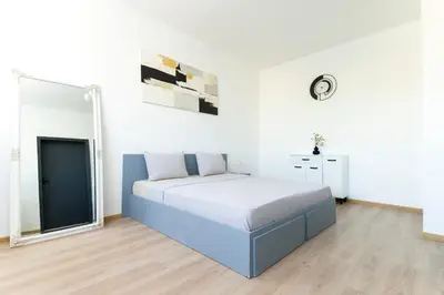 a bedroom with a large bed in a white room at Sunny Top Floor Apartment near Tokuda Hospital & Paradise Mall in Sofia