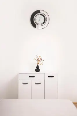a white cabinet with a clock on top of it at Sunny Top Floor Apartment near Tokuda Hospital & Paradise Mall in Sofia