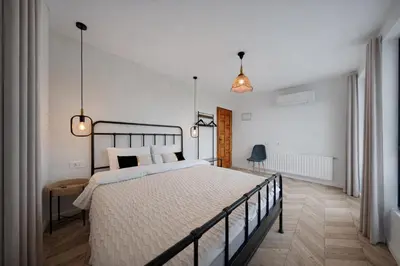 a bedroom with a large bed and two pendant lights at Villa High Point in Pravets