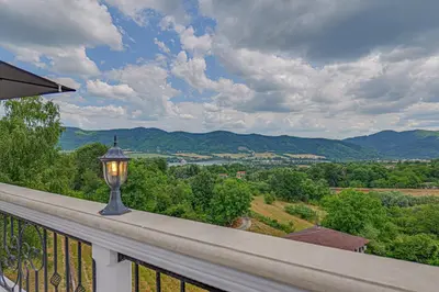 a lamp on a balcony with a view of the mountains at Villa High Point in Pravets