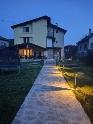 a stone pathway leading to a house at dusk at The Bird Villa in Bosnek