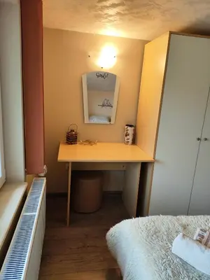 a desk in a bedroom with a bed and a mirror at The Bird Villa in Bosnek