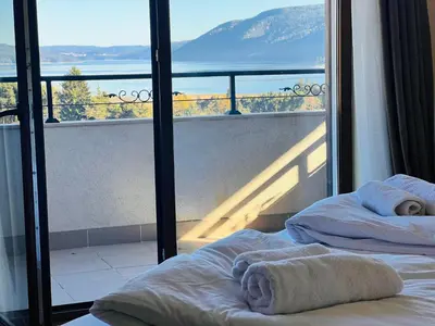 a bedroom with two beds and a balcony with a view at Ardo Hill Spa Hotel and Restaurant in Sarnitsa