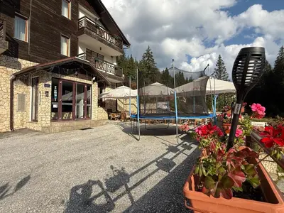 a patio with a pool and a building and flowers at Forest Retreat, Stream Resort, Pamporovo in Stoykite
