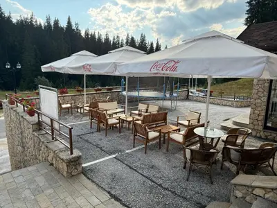 a restaurant with tables and chairs and umbrellas at Forest Retreat, Stream Resort, Pamporovo in Stoykite
