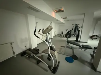a gym with a exercise bike and two chairs at Forest Retreat, Stream Resort, Pamporovo in Stoykite