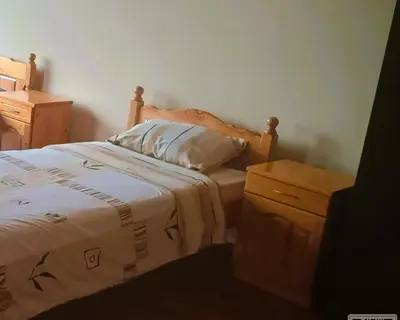 a bedroom with a bed with a pillow and a dresser at Uspeh bg in Plovdiv