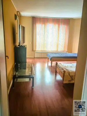 a room with a bed and a table and a tv at Uspeh bg in Plovdiv