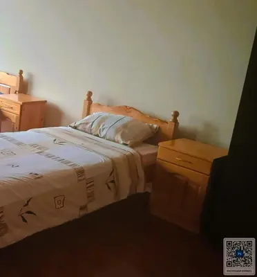 a bedroom with a bed with a pillow and a night stand at Uspeh bg in Plovdiv
