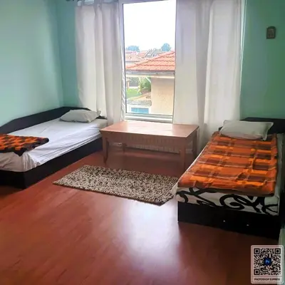 a room with two beds and a window at Uspeh bg in Plovdiv