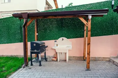 a barbecue grill and a white sink under a pavilion at Къща Инфинити Лукс и Уют, Вплетени в Спомени in Sapareva Banya