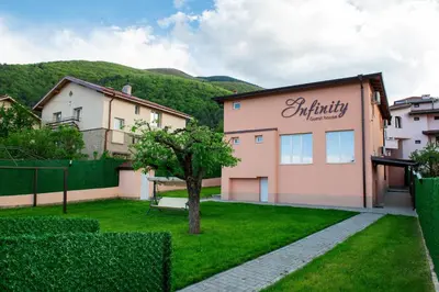 a house with a sign on the side of it at Апартамент Инфинити in Sapareva Banya