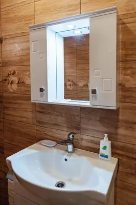 a bathroom with a white sink and a mirror at Апартамент Инфинити in Sapareva Banya