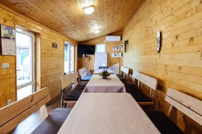 a row of tables in a room with wooden walls at Апартамент Инфинити in Sapareva Banya