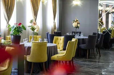 a dining room with tables and yellow chairs at Hotel Monte Cristo in Blagoevgrad