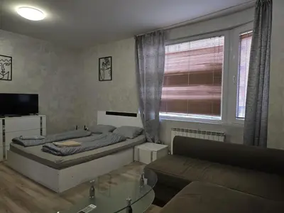 a bedroom with a bed and a couch and a window at The Alma Mater in Sofia