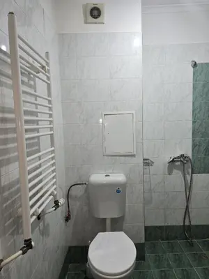 a bathroom with a white toilet and a shower at The Alma Mater in Sofia
