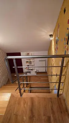 a staircase with a railing next to a wall at Арт мезонет под тепето in Plovdiv