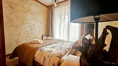 a bedroom with a bed and a large window at Forest nest Cozy apartment white balcony on the hill in Bansko