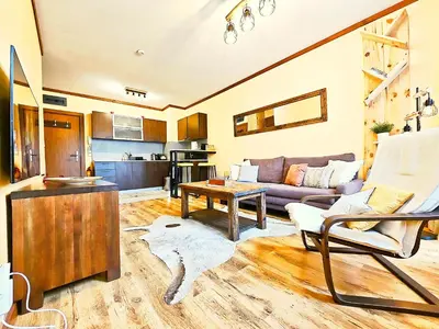 a living room with a couch and a table at Forest nest Cozy apartment white balcony on the hill in Bansko