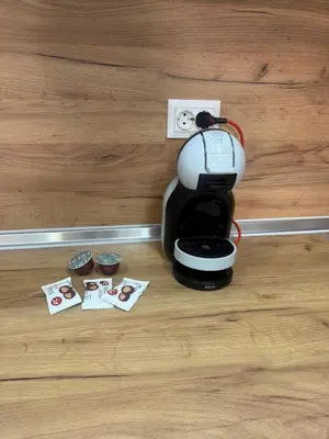 a coffee maker sitting on top of a wooden floor at White lux in Sandanski
