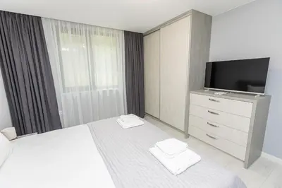 a bedroom with a bed with a tv and a dresser at White lux in Sandanski