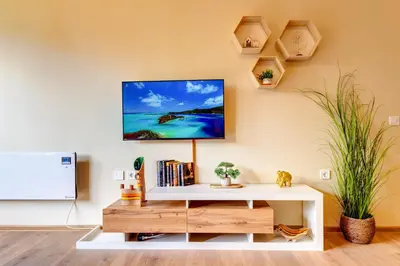 a living room with a tv on the wall at Forest Harmony 1BD with Balcony & Parking by Flat Manаger in Smolyan