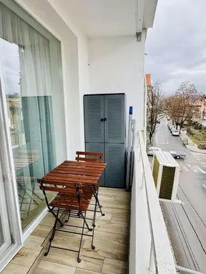 a bench on a balcony with a view of a street at Unique flat with balcony in the heart of the city in Kyustendil