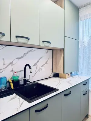 a kitchen with a sink and a marble counter top at Unique flat with balcony in the heart of the city in Kyustendil