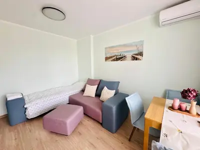 a room with a couch and a bed and a table at Unique flat with balcony in the heart of the city in Kyustendil